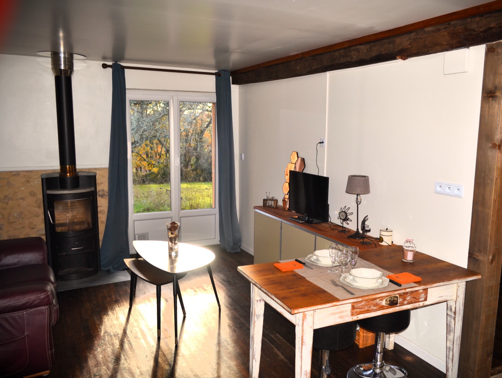 Gîte Eden — Le salon, son poêle à bois et le coin repas