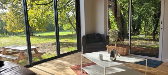 Gîte Mathys — La pièce de vie ouverte sur le bois